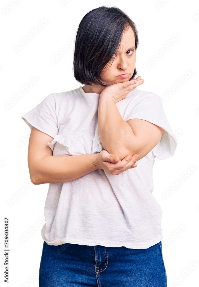 Brunette woman with down syndrome wearing casual white tshirt thinking looking tired and bored with depression problems with crossed arms. Brunette woman with down syndrome wearing casual white tshirt thinking looking tired and bored with depression problems with crossed arms.