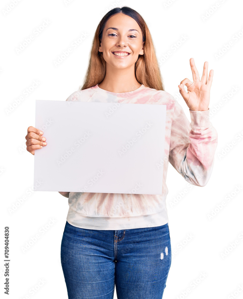 Beautiful young woman holding blank empty banner doing ok sign with fingers, smiling friendly gesturing excellent symbol Beautiful young woman holding blank empty banner doing ok sign with fingers, smiling friendly gesturing excellent symbol