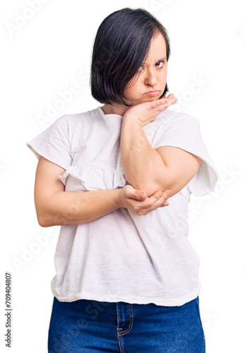 Brunette woman with down syndrome wearing casual white tshirt thinking looking tired and bored with depression problems with crossed arms. © Krakenimages.com