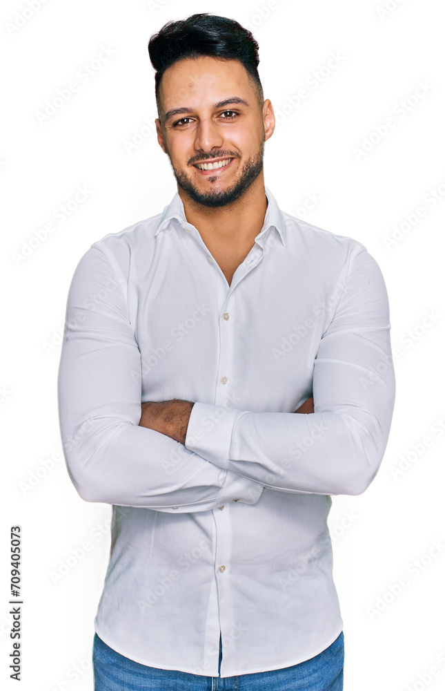 Young arab man wearing casual clothes happy face smiling with crossed arms looking at the camera. positive person. Young arab man wearing casual clothes happy face smiling with crossed arms looking at the camera. positive person.