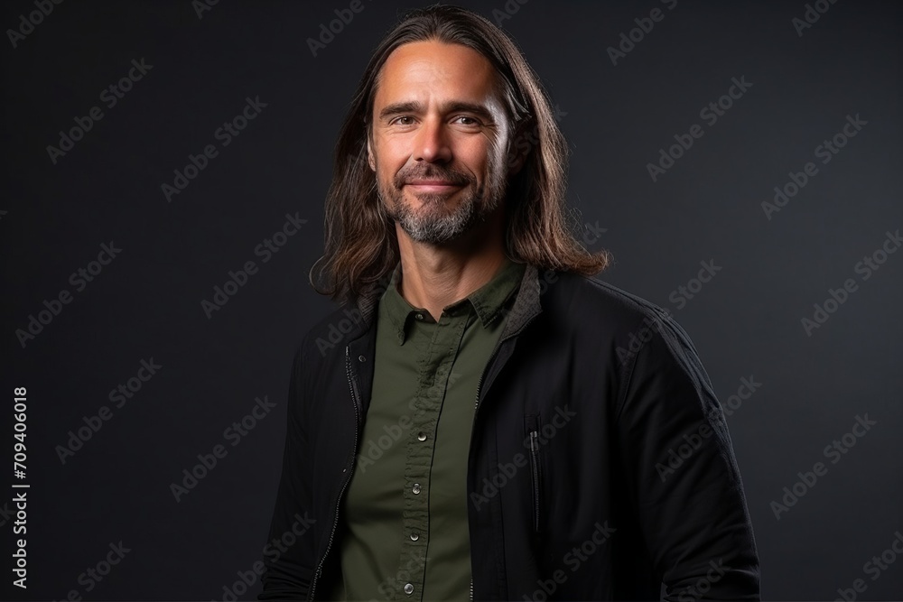 Handsome middle age man with long hair and beard over black background Handsome middle age man with long hair and beard over black background