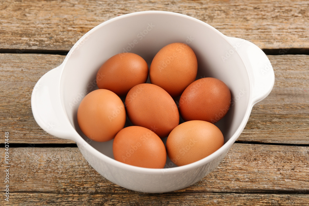 Unpeeled boiled eggs in saucepan on old wooden table, closeup Unpeeled boiled eggs in saucepan on old wooden table, closeup