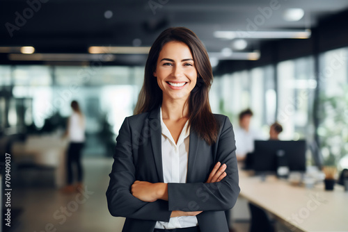 Confident Businesswoman with Arms Crossed Smiling in Modern Office Environment, Professional Leadership Concept