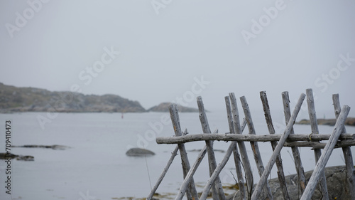 Wood picket fence at the edge of the waters on Fogo Island in Newfoundland-Labrador in mist and fog