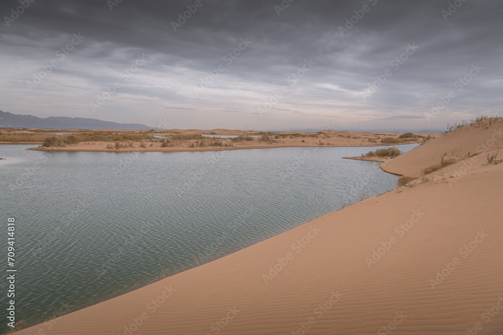 Desert vastness next to lake in Wuhai, Inner Mongolia, China