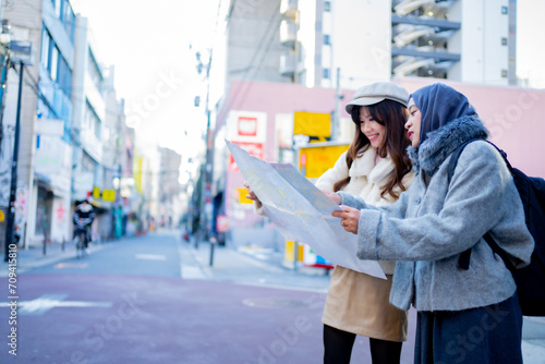 woman girl tourist Two Asian friends but different religions, one of whom is a Muslim girl. Looking at the tour map View information on traveling in Japan. with fun She is traveling in the city area. photo