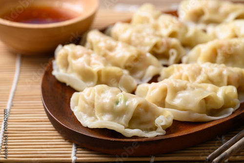Steamed wonton dumpling stuffed with minced pork and chicken eating with sesame oil sauce photo