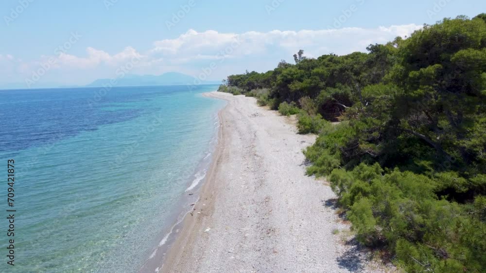 A drone flies parallel to an empty, pristine beach along the Greek coastline A drone flies parallel to an empty, pristine beach along the Greek coastline