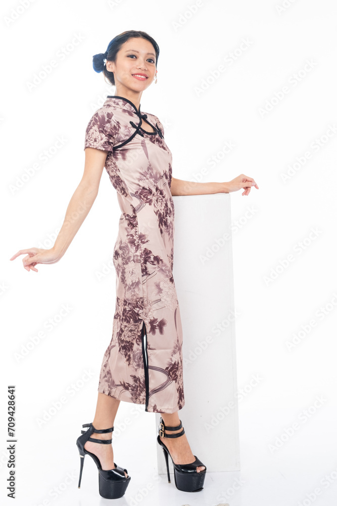 Portrait of an attractive Asian Chinese female wearing cheongsam or qipao isolated on white background for Chinese New Year concept Portrait of an attractive Asian Chinese female wearing cheongsam or qipao isolated on white background for Chinese New Year concept
