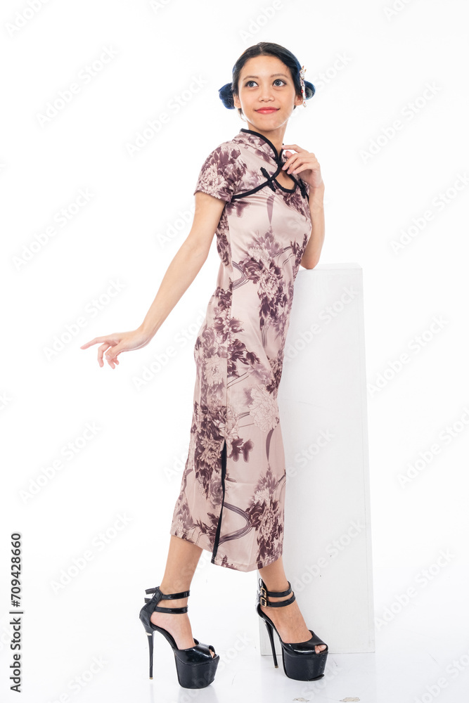 Portrait of an attractive Asian Chinese female wearing cheongsam or qipao isolated on white background for Chinese New Year concept Portrait of an attractive Asian Chinese female wearing cheongsam or qipao isolated on white background for Chinese New Year concept