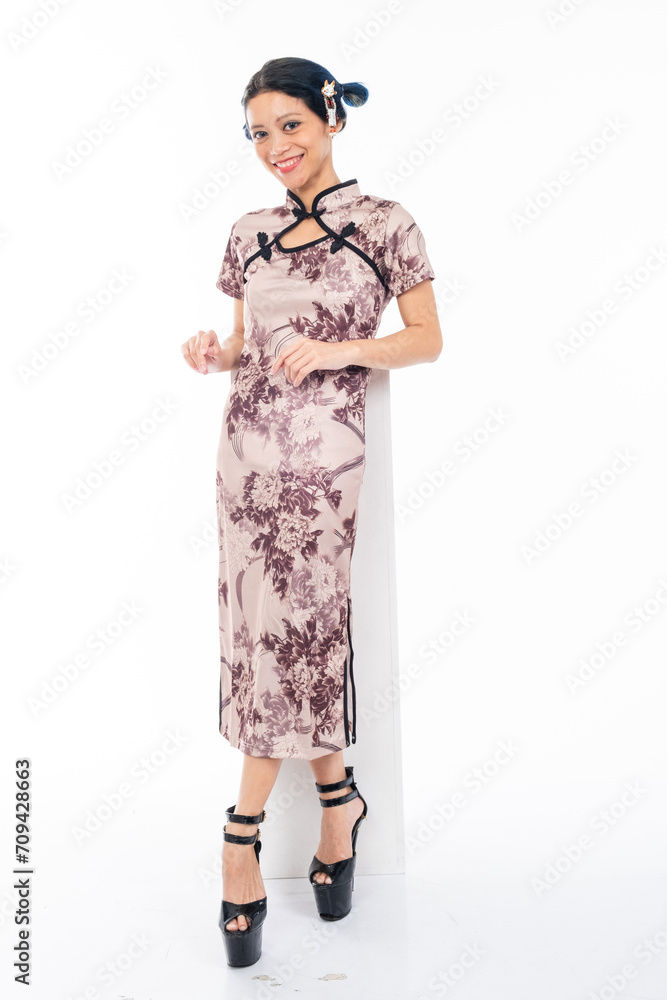 Portrait of an attractive Asian Chinese female wearing cheongsam or qipao isolated on white background for Chinese New Year concept Portrait of an attractive Asian Chinese female wearing cheongsam or qipao isolated on white background for Chinese New Year concept
