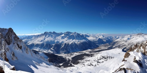 Dramatic mountain range covered in snow with a clear blue sky