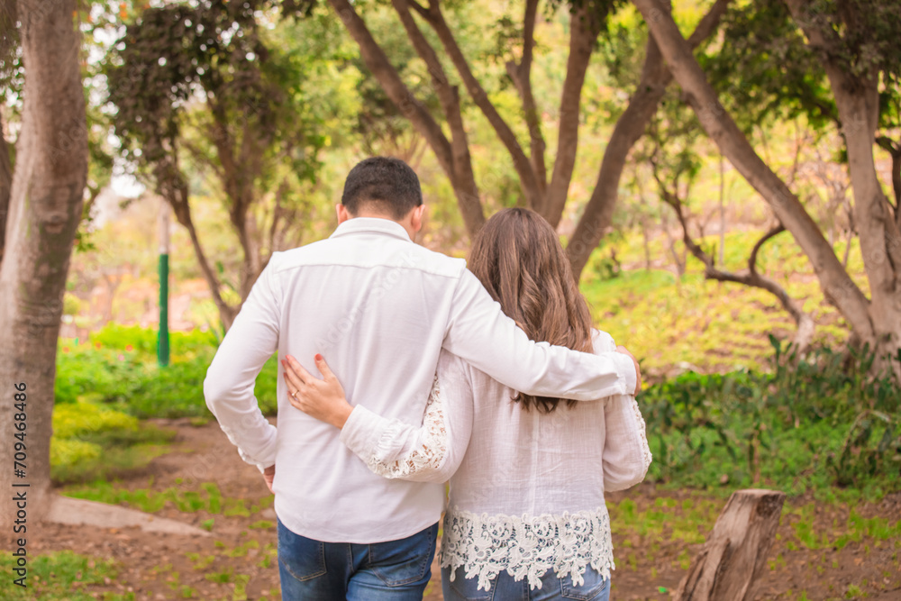 Fototapeta premium Family members holding hands and walking backwards in a park together family