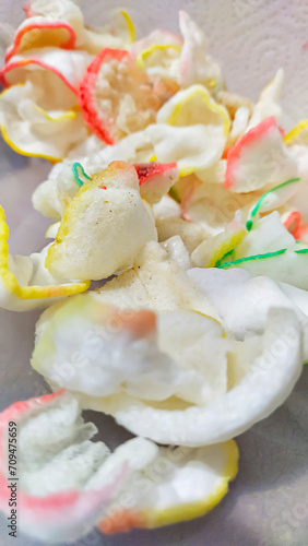 close up of shrimp crackers with colorful edges in a plastic container