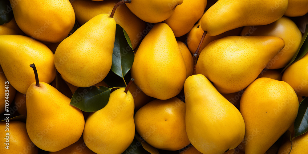 Natural background of fresh ripe yellow pears. Full frame A quality product Healthy eating. Close-up Top view fruit background with fresh yellow pears green leaves.