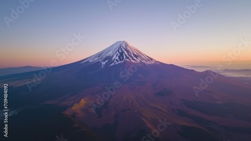 Aerial view of a lone, snow-capped mountain peak, at sunset photo