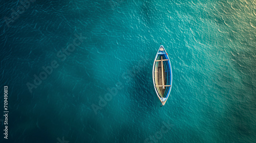 A small deserted rowboat drifts in the center of the ocean photo