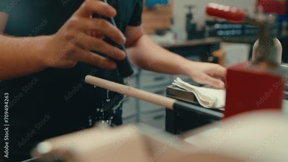 Caucasian male hands work in slow motion to pour dripping water over exposed grip on golf club shaft in preparation for custom fitting golf irons Caucasian male hands work in slow motion to pour dripping water over exposed grip on golf club shaft in preparation for custom fitting golf irons