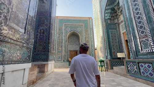 Young Man Admires Mausoleum of Khoja Ahmad at Shah-i-Zinda, Samarkand, Uzbekistan; 4K Footage Highlights Persian-Mongolian Architecture, Vibrant Tiles, and Silk Road History in a UNESCO Site. photo