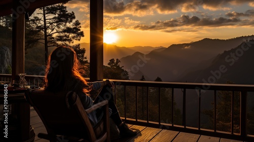 a female traveler sitting and looking at a beautiful sunrise on foggy day photo