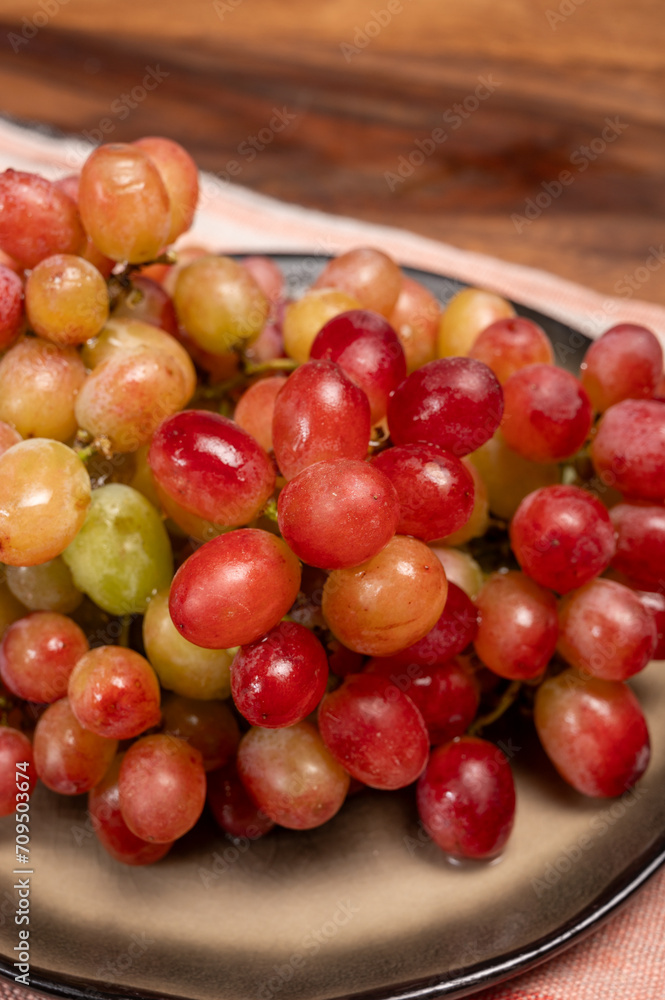 Sweet washed ripe pink grapes berries on board ready to eat Sweet washed ripe pink grapes berries on board ready to eat