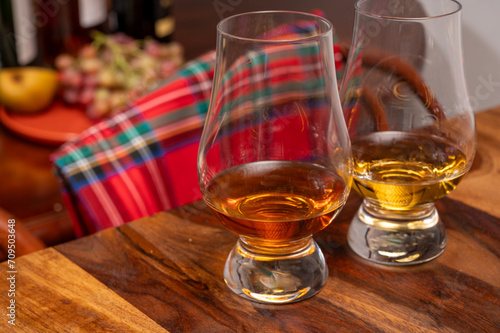 Fototapeta Naklejka Na Ścianę i Meble -  Tasting of different Scotch whiskies strong alcoholic drinks, drum of whiskey and colorful Scotch tartan on background close up
