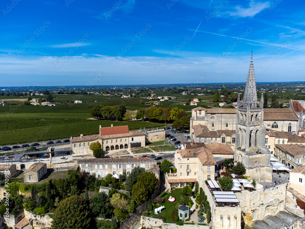 Fototapeta premium Aerial views of green vineyards, old houses and streets of medieval town St. Emilion, production of red Bordeaux wine on cru class vineyards in Saint-Emilion wine making region, France, Bordeaux
