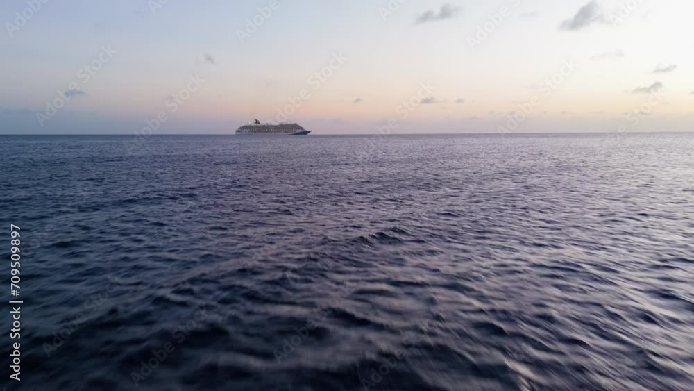Low flying aerial dolly to cruise ship in open ocean at dusk, stunning cinematic sunset Low flying aerial dolly to cruise ship in open ocean at dusk, stunning cinematic sunset