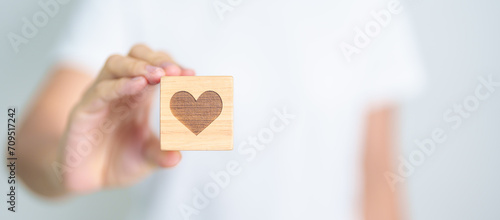 Hand holding heart block for health care, love, organ donation, charity, happy family, wellbeing and insurance concepts. world heart day, health day and mental health day photo