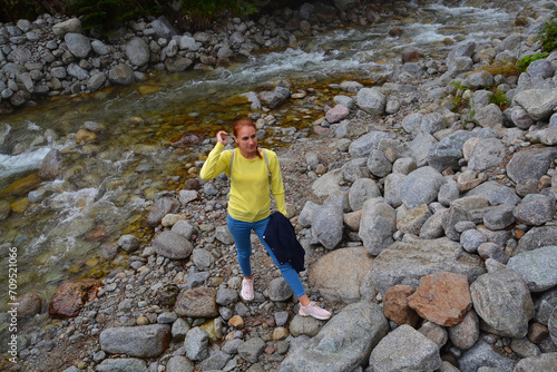 Young woman and rocky stream of Kezmarska Biela voda in the Tatra mountain photo
