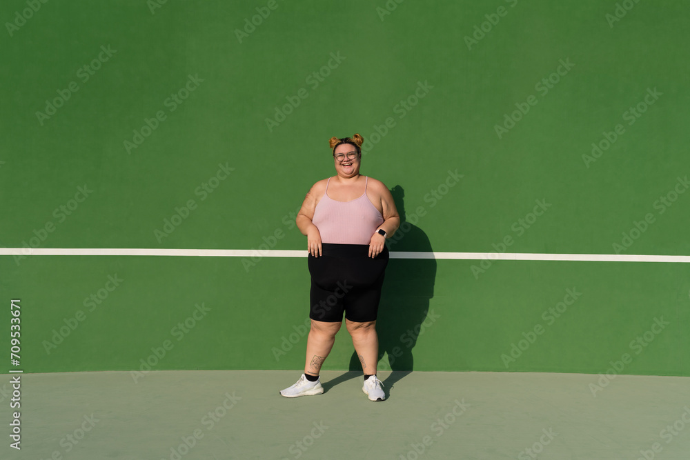 Full length portrait of a plump woman against green background