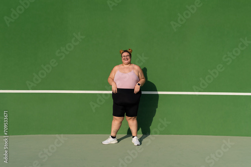 Full length portrait of a plump woman against green background