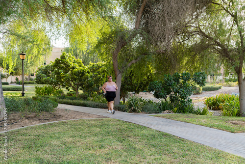 Valokuva Portrait of a plump woman exercising outdoors doing brisk walking