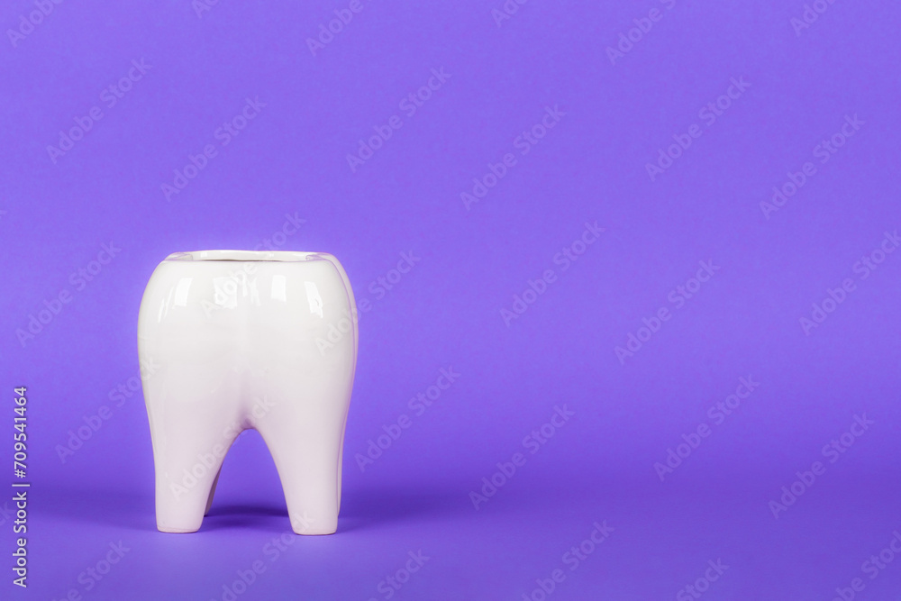 White ceramic tooth in bright colorful background. Free space for text.