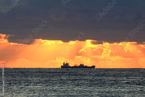 commercial shipping with sunrise and dark clouds