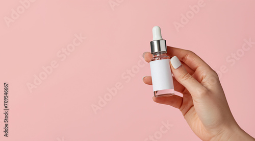 woman's Hand Holding an amber glass dropper Bottle on a light pink Background Stock Image, a mockup of a cosmetic serum container with a dropper lid, Blank Label Dropper Bottle photo