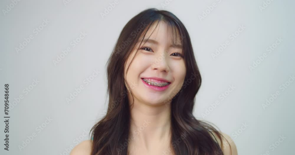 Happy beautiful asian girl with braces. She looking to camera with attractive smiling at white background. Happy beautiful asian girl with braces. She looking to camera with attractive smiling at white background.