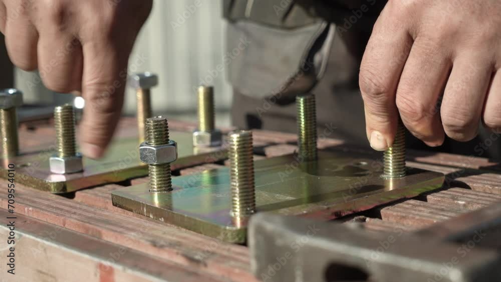 Assembler's hands tightening a Nut onto a Bolt Assembler's hands tightening a Nut onto a Bolt