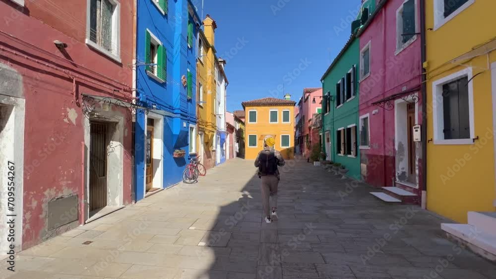Walking Through Burano: Young Tourist Marvels at Colorful Streets and History in Venice's Picturesque Island. Enjoying the Pastel Buildings, Famous Lace Craft and Rich Culture of Italy