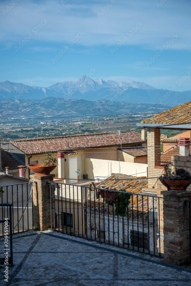 Mountain view from the terrace of the house, Italy. The village of Montepagano, Roseto degli Abruzzi. A sunny summer day. Travel to Europe, tourism. Tiled roofs.