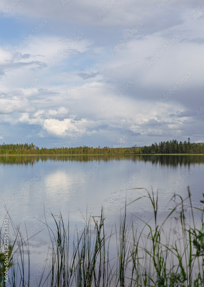 Beautiful and calm scenery at the lake shore on a cloudy day in Finland.