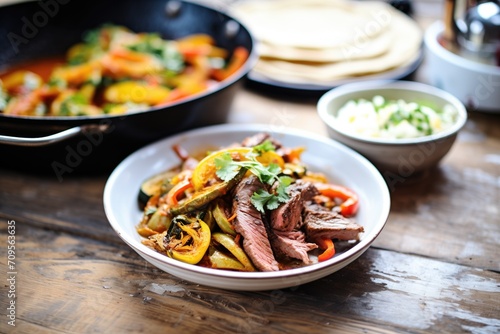 beef fajitas with charred veggies and spicy sauce on side