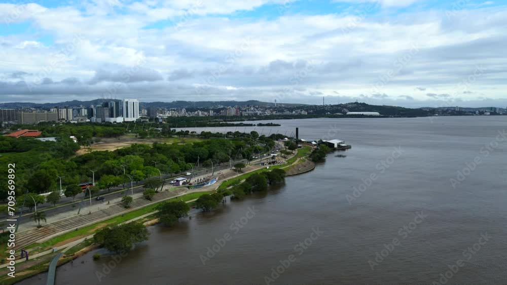 Aerial shot drone flies far from coast with green park and coastal road Aerial shot drone flies far from coast with green park and coastal road