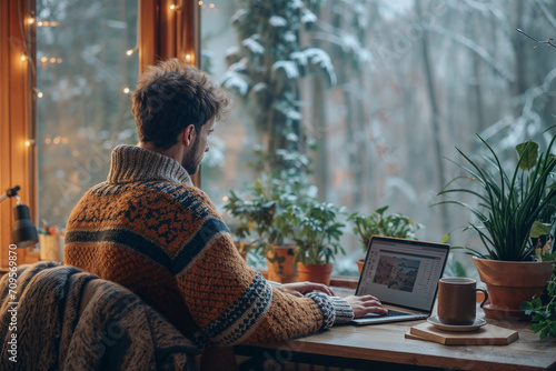 Man working from home at his plant lovers desk with a forest view in his cabin