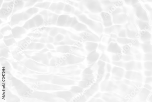 White water with ripples on the surface. Defocus blurred transparent white colored clear calm water surface texture with splashes and bubbles. Water waves with shining pattern texture background.