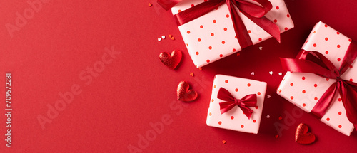 Valentines Day banner design. Top view gift boxes with red ribbon bows, hearts, confetti on red background
