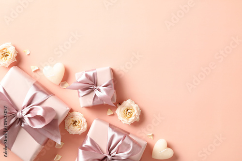 Happy Valentine's day flat lay composition with gift boxes, candles, flowers on beige background. Top view.