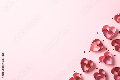 Top view St Valentines Day paper cut hearts with confetti on pink table. Flat lay.