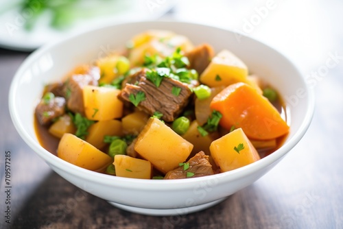 a bowl of pot roast stew with peas and potatoes
