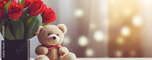 Close-up photo of a bouquet of red tulips and a teddy bear on a blurred background. Holiday gift concept for World Women's Day, March 8, birthday, anniversary with copy space. Banner, postcard. photo